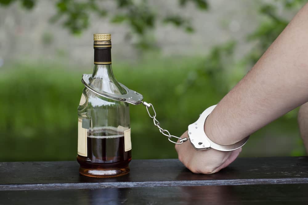 handcuffed to liquor bottle